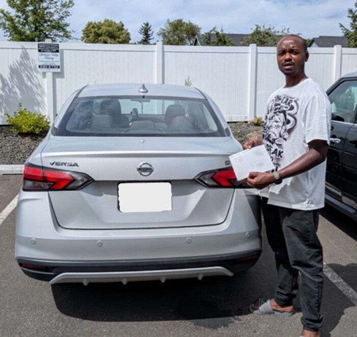 Joseph with his check and car